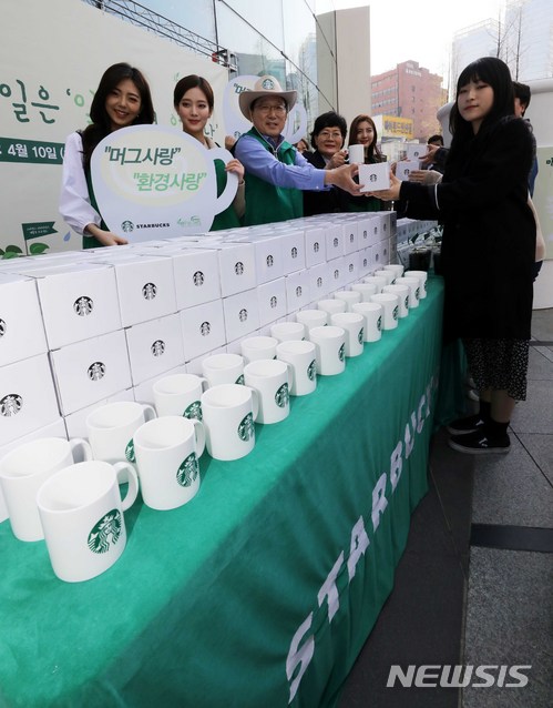 【서울=뉴시스】고범준 기자 = 10일 오전 서울 종로구 스타벅스 더종로점 입구 앞 광장에서 이석구 스타벅스커피 코리아 대표(가운데), 김미화 자원순환사회연대 사무총장 등 참석자들이 시민들에게 머그 증정을 하고 있다. 스타벅스는 '일(1)회용컵 없는(0)' 날을 상징적으로 기억하기 쉬운 매월 10일을 캠페인의 날로 정하고, 4월부터 6월까지 매월 10일 3회에 걸쳐 전국 스타벅스 매장에서 다회용컵 사용 촉진을 위한 고객 참여 캠페인을 진행한다. 2018.04.10. bjko@newsis.com