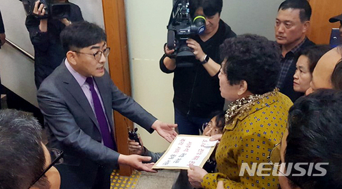 【서울=뉴시스】김성진 기자 = 10일 국방부에서 '오월을 사랑하는 사람들의 모임' 회원이 국방부 차관 보좌관에게 항의 서한을 전달하고 있다. 단체는 5·18 왜곡 조직에서 활동했던 서주석 차관의 퇴진을 촉구했다. 2018.04.10. ksj87@newsis.com