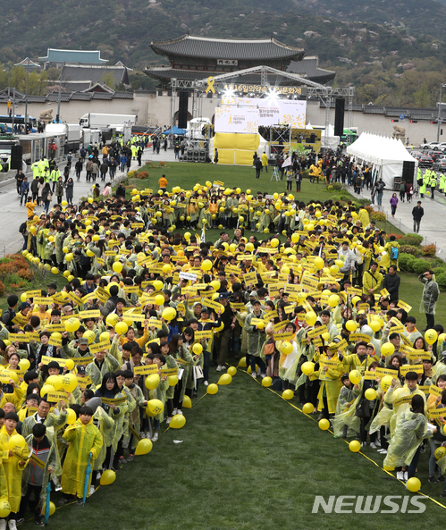 【서울=뉴시스】권현구 기자 = 14일 오후 서울 종로구 광화문광장에서 열린 세월호 참사 4주기 국민참여행사에 참석한 시민들이 세월호리본을 만드는 플래시몹을 하고 있다. 2018.04.14.&nbsp; stoweon@newsis.com