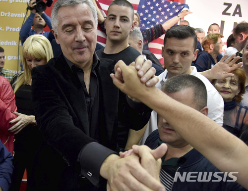 【포드고리차( 몬테네그로)=AP/뉴시스】 몬테네그로의 대통령으로 당선된 밀로 주카노비치 전총리(왼쪽)가 15일 당선이 확정된 후 포드고리차에서 축하하는 지지자들과 악수를 나누고 있다. 2018.04.16&nbsp; 