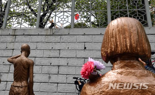 【부산=뉴시스】 하경민 기자 = 17일 부산 동구 일본영사관 앞에서 적폐청산·사회대개혁 부산운동본부 강제징용노동자상 건립특별위원회가 강제징용노동자상 건립 계획 발표 기자회견을 하고 있는 가운데 부산 평화의 소녀상과 노동자상 모형 위로 일본영사관 내 일장기가 휘날리고 있다.&nbsp; 위원회는 지난해 9월부터 강제징용노동자상 건립을 위한 모금운동을 벌여 1억원(220개 단체, 6533명) 상당을 모았고, 이 모금액으로 강제징용노동자상을 제작해 오는 5월 1일 노동절에 맞춰 부산 일본영사관 앞 평화의 소녀상 옆에 노동자상을 세울 계획이다. 2018.04.17.&nbsp; yulnetphoto@newsis.com