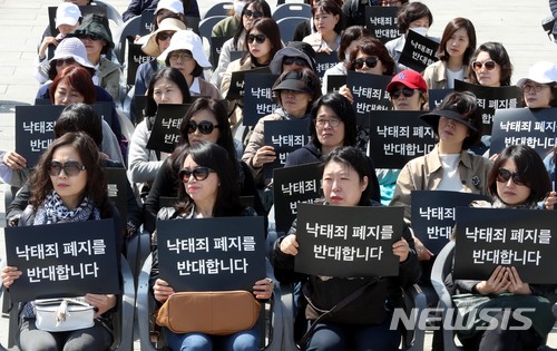 【서울=뉴시스】조성봉 기자 = 18일 오전 서울 종로구 광화문 광장에서 열린 여성과 태아의 생명사랑 생명보호대회에서 참석자들이 '낙태죄 폐지 반대' 손피켓을 들고 있다. 2018.04.18. suncho21@newsis.com