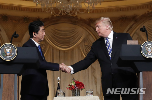 【팜비치(미 플로리다주)=AP/뉴시스】도널드 트럼프 미 대통령(오른쪽)과 아베 신조(安倍晉三) 일본 총리가 18일(현지시간) 플로리다주 팜비치에 있는 트럼프 대통령의 개인 별장 마라라고 클럽에서 공동기자회견 중 악수하고 있다. 2018.4.19 