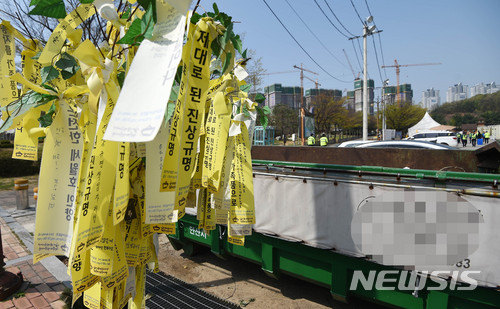 【안산=뉴시스】이정선 기자 = 세월호참사 희생자 정부합동분향소 철거가 시작된 19일 오전 경기 안산 세월호참사 분향소 외부 폐기물 수거함에 추모 리본이 달린 나무가 버려졌다가 다시 밖으로 꺼내져 있다. 2018.04.19. ppljs@newsis.com