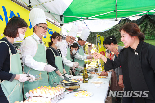 【창원=뉴시스】 홍정명 기자 = 지난 20일 농협 경남지역본부 앞 금요직거래큰장터에서 열린 '계란 소비촉진을 위한 계란요리 시식 행사'에 참여한 하명곤(왼쪽 두 번째) 경남농협 본부장이 장터를 찾은 고객들에게 줄 계란 요리를 하고 있다.2018.04.21.(사진=경남농협 제공) photo@newsis.com