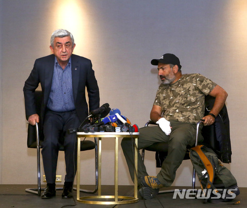 In this photo taken on Sunday, April 22, 2018, former Armenian President Serzh Sargsyan, left, leaves a meeting with protest leader Nikol Pashinian, right, in Yerevan, Armenia. Armenian Prime Minister Serzh Sargsyan has resigned, according to his website. (Hrant Khachatryan/PAN Photo via AP)
