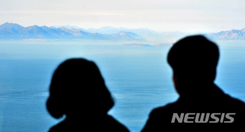 【서울=뉴시스】 남북정상회담이 오는 27일 경기도 파주 판문점에서 열린다. 분단 이후 처음으로 북한 최고지도자가 남한 땅을 밟는 이번 회담은 비핵화, 평화정착, 남북관계 발전 등의 의제를 중심적으로 진행될 예정이다.&nbsp; 사진은 지난 20일 서해 최북단 백령도를 찾은 관광객들이 백령땅끝 전망대에서 김정은 북한 국무위원장이 방문한 북한 황해남도의 월내도를 바라보고 있는 모습. 2018.04.25. (사진=경인일보 제공)&nbsp; photo@newsis.com