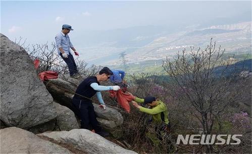  【부산=뉴시스】허상천 기자 = 부산시는 28일부터 내달 20일까지 차량이 진입 할 수 없거나 쓰레기를 버린 사람을 찾지 못해 방치돼 있는 금정산 내 폐기물들을 모두 수거할 계획이라고 밝혔다. 사진은 금정산 고담봉 부근 암릉에서 환경정화활동을 하고 있는 모습. 2021.04.28. (사진 = 부산시 제공) photo@newsis.com