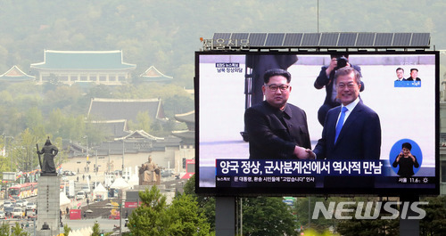 【서울=뉴시스】임태훈 기자 = 27일 오전 서울 중구 프레스센터 전광판에 남북정상회담을 앞두고 만난 문재인 대통령과 김정은 북한 노동당 위원장이 악수하는 모습이 생중계되고 있다. 2018.04.27.&nbsp; taehoonlim@newsis.com