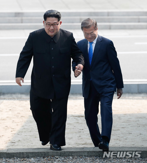 【판문점=뉴시스】한국공동사진기자단 = 2018 남북정상회담이열린 27일 오전 문재인 대통령과 김정은 북한 국무위원장이 함께 군사분계선(MDL)을 넘어오고 있다. 2018.04.27  photo@newsis.com