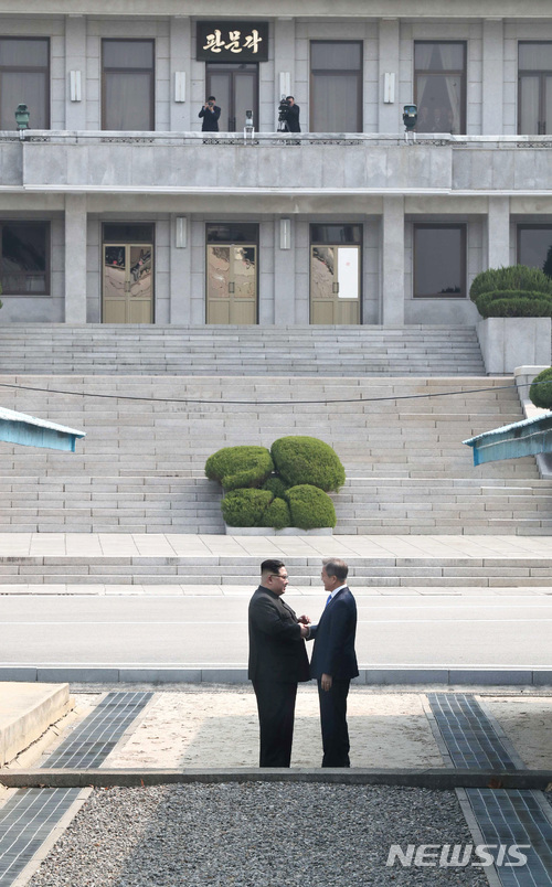 【판문점=뉴시스】전신 기자 = 문재인 대통령과 김정은 국무위원장이 27일 오전 판문점 군사정전위원회 사무실 사이의 군사분계선(MDL)을 북측으로 넘어가 손을 잡고 있다. 2018.04.27.  photo1006@newsis.com 