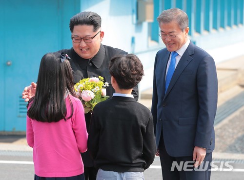 【판문점=뉴시스】한국공동사진기자단 = 2018 남북정상회담이 열린 27일 오전 문재인 대통령과 김정은 북한 국무위원장이 판문점에서 화동으로 부터 꽃을 받고 있다. 2018.04.27.&nbsp; photo@newsis.com