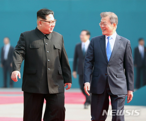 【판문점=뉴시스】한국공동사진기자단 = 문재인 대통령과 김정은 국무위원장이 27일 오전 판문점 평화의집앞에서 국군의장대 사열을 마친 후 정상회담장으로 이동하며 대화를 나누고 있다. 2018.4.27 photo@newsis.com