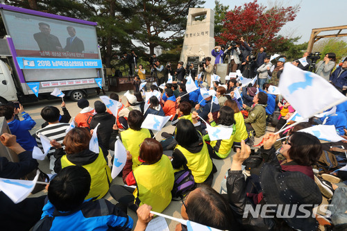 【파주=뉴시스】배훈식 기자 = 2018 남북 정상회담이 열린 27일 오전 경기 파주시 임진각에서 겨레하나 등 시민사회단체 회원들과 시민들이 문재인 대통령과 김정은 북한 노동당위원장이 만나 악수하자 한반도기를 흔들며 환호하고 있다. 2018.04.27. dahora83@newsis.com