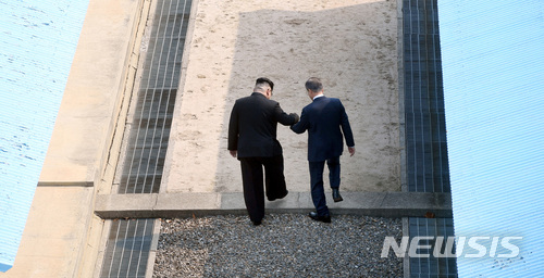 【판문점=뉴시스】전신 기자 = 문재인 대통령이 27일 경기 파주시 판문점 군사분계선을 북한 김정은 국무위원회 위원장과 함께 넘고 있다. 2018.04.27.&nbsp; photo1006@newsis.com