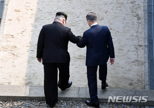 【판문점=뉴시스】전신 기자 = 2018 남북정상회담이 열린 27일 경기도 파주시 판문점에서 문재인 대통령이 북한 김정은 국무위원장의 손을 잡고 군사분계선을 넘어 북측으로 향하고 있다. 2018.04.27&nbsp; photo1006@newsis.com