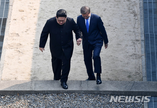 【판문점=뉴시스】전신 기자 = 2018 남북정상회담이 열린 27일 경기도 파주시 판문점에서 문재인 대통령이 북한 김정은 국무위원장의 손을 잡고 군사분계선을 넘어 북측 지역에갔다 다시 남측지역으로 향하고 있다.2018.04.27&nbsp; photo1006@newsis.com