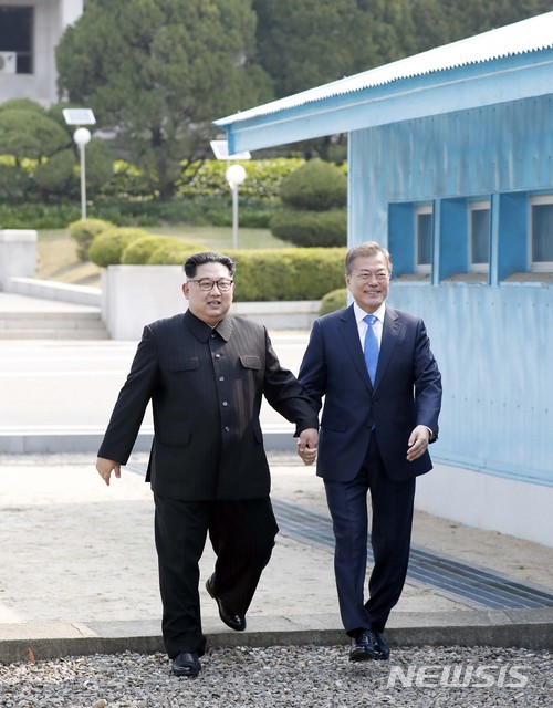 【판문점=뉴시스】전신 기자 = 문재인 대통령과 김정은 국무위원장이 27일 판문점에서 손을 잡고 군사분계선을 넘고 있다. 2018.04.27.&nbsp; photo1006@newsis.com
