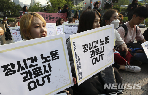 【서울=뉴시스】최진석 기자 = 제128주년 노동절을 하루 앞둔 30일 오후 서울 청계광장에서 청년학생문화제 기획단 단원들이 근로시간 단축 촉구 문구가 적힌 팻말을 들고 있다. 2018.04.30.&nbsp; myjs@newsis.com