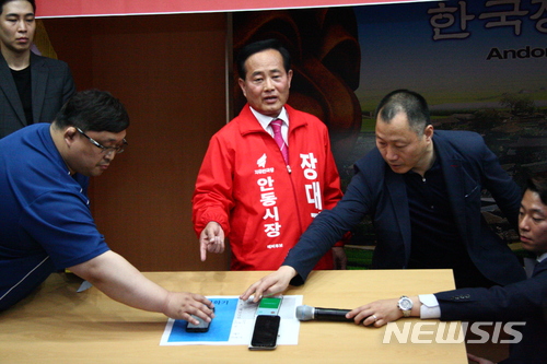 【안동=뉴시스】김진호 기자 = 6·13 전국동시지방선거 경북 안동시장 선거에 출마한 자유한국당 장대진 예비후보는 1일 안동시청 회의실에서 기자회견을 갖고 "안심번호는 얼마든지 조작이 가능하다"며 자유한국당 경북도당이 지난달 25~26일 실시한 안동시장 후보경선 여론조사 결과에 의의를 제기했다. 장 예비후보가 3대의 휴대폰을 이용해 안심번호가 어떻게 조작되는지를 설명하고 있다. 2018.05.01&nbsp; kjh9326@newsis.com