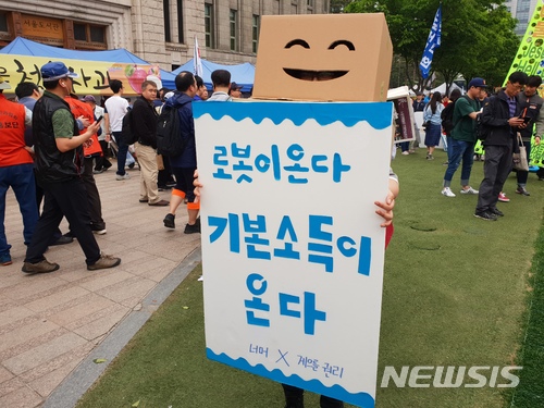 【서울=뉴시스】허성훤 수습기자 = 1일 세계노동자의날을 맞아 서울 중구 서울광장에서 열린 '2018 세계노동절대회'가 열린 가운데, 청년모임 '게으를권리'와 청년정치공동체 '너머'가 보편적 기본소득 도입을 촉구하기 위해 로봇 코스튬을 입고 퍼포먼스를 진행하고 있다. 2018.05.01. photo@newsis.com