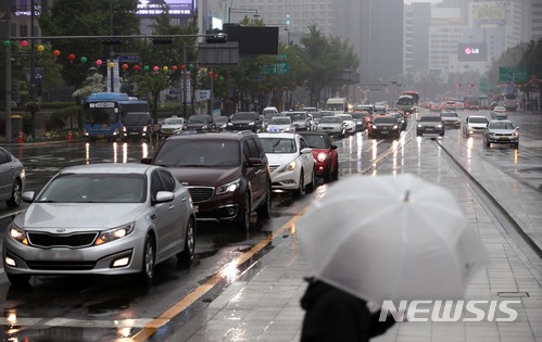 【서울=뉴시스】김선웅 기자 = 서울 지역에 비가 내린 2일 서울 종로구 광화문광장에서 우산을 쓴 시민이 길을 걷는 너머로 전조등을 켠 차량들이 신호를 기다리고 있다. 2018.05.02. mangusta@newsis.com
