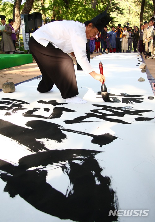 【영주=뉴시스】김진호 기자 = 4일 경북 영주시 소수서원에서 열린 '영주 소수서원 유교성지 선포식'에서 박기진 대한민국 서예대전 초대작가 겸 심사위원이 유교성지 선포 기념 퍼포먼스 서예를 선보이고 있다. 2018.05.04 kjh9326@newsis.com
