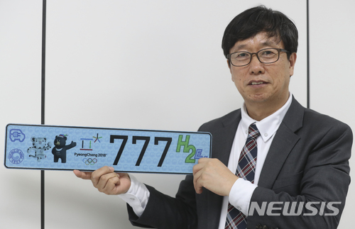 【서울=뉴시스】최진석 기자 = 신재행 수소융합얼라이언스추진단장이 4일 오후 서울 금천구 수소융합얼라이언스추진단에서 뉴시스와 인터뷰에 앞서 수소·전기차 번호판을 들고 포즈를 취하고 있다. 2018.05.04. myjs@newsis.com