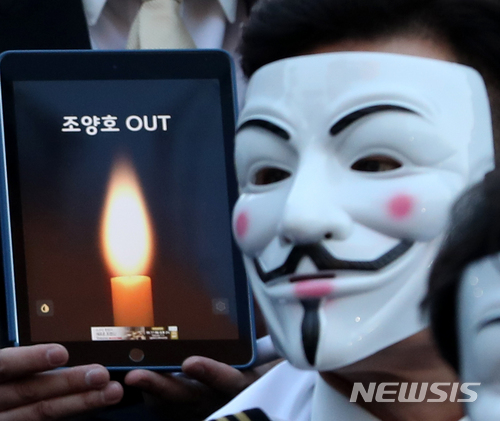 【서울=뉴시스】박주성 기자 = 대한항공 직원들과 시민들이 4일 오후 서울 광화문 세종문화회관 옆 계단에서 '조양호일가 및 경영진 퇴진 갑질 STOP 촛불집회'에 저항을 상징하는 벤데타 가면과 선글라스를 끼고 참석하고 있다. 2018.05.04. park7691@newsis.com