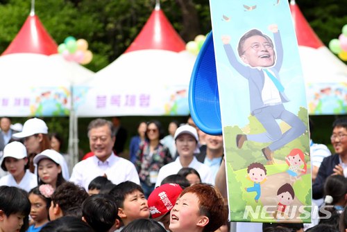 【서울=뉴시스】전신 기자 = 문재인 대통령이 5일 청와대 녹지원에서 열린 어린이날 청와대 초청행사에서 어린이들과 함께 박 터뜨리기를 하고 있다. 2018.05.05. photo1006@newsis.com