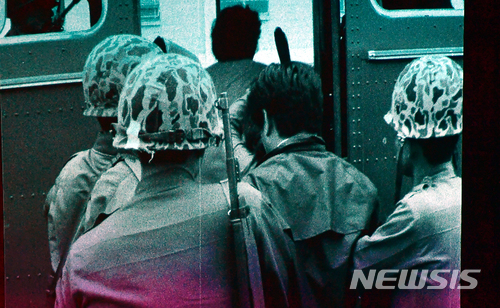 【광주=뉴시스】류형근 기자 = 1980년 5·18민주화운동 당시 계엄군의 잔혹함과 시민들의 분노, 항쟁이 끝난 뒤 광주 모습이 담긴 영상이 38년만인 9일 오후 광주 동구 국립아시아문화전당 극장3에서 처음 공개됐다. 한 시민이 계엄군에 의해 연행되고 있다. 2018.05.09. (사진=5·18민주화운동기록관 공개 영상 촬영)&nbsp; photo@newsis.com