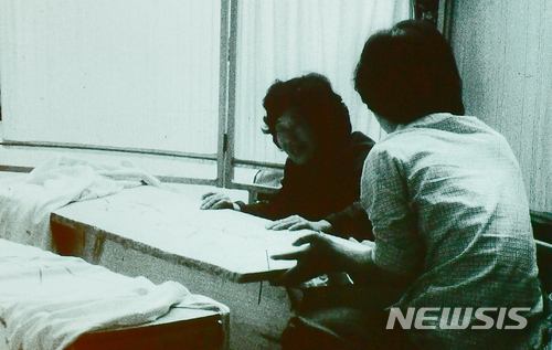 【광주=뉴시스】류형근 기자 = 1980년 5·18민주화운동 당시 계엄군의 잔혹함과 시민들의 분노, 항쟁이 끝난 뒤 광주 모습이 담긴 영상이 38년만인 9일 오후 광주 동구 국립아시아문화전당 극장3에서 처음 공개됐다. 한 가족이 관속에 잠들어 있는 희생자를 확인한 뒤 오열하고 있다. 2018.05.09. (사진=5·18민주화운동기록관 공개 영상 촬영) photo@newsis.com