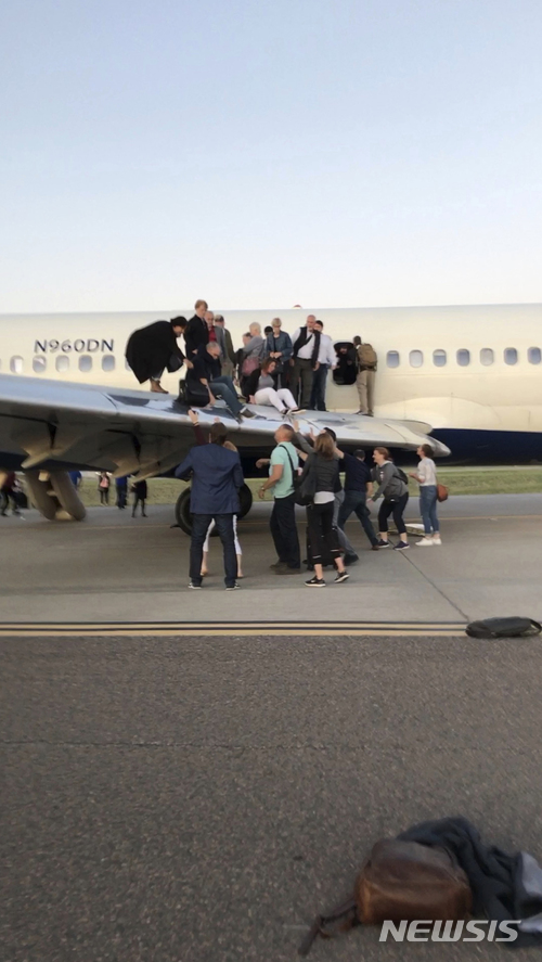 【덴버(미 콜로라도주)=AP/뉴시스】8일(현지시간) 미 콜로라도주 덴버 국제공항에 비상착륙한 델타항공 여객기에서 승객들이 활주로로 탈출하고 있다. 153명의 승객을 태우고 디트로이트를 출발한 이 여객기는 승객들이 객실에서 연기가 나는 것을 목격하자 덴버 공항에 비상착륙했다. 2018.5.9