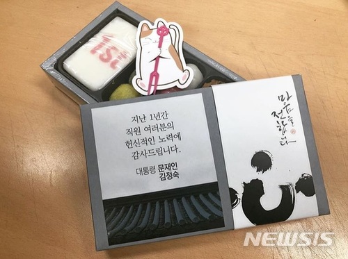【서울=뉴시스】 문재인 대통령과 김정숙 여사는 "1년간 직원 여러분의 헌신적인 노력에 감사드린다"며 전 직원들에게 '취임 1주년 기념 떡'을 돌렸다. 떡을 찍어 먹는 포크는 문 대통령이 기르는 고양이 '찡찡이'를 떠올리는 포장지로 감쌌다. (사진=청와대 인스타그램). 2018.05.10. photo@newsis.com