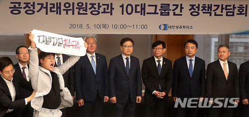 【서울=뉴시스】추상철 기자 =공정거래위원장과 10대그룹간 정책간담회가 열린 10일 오전 서울 중구 대한상공회의소에서 김상조 공정거래위원장을 비롯한 10대그룹 경영진이 기념촬영을 하는 중 금속노조 조합원이 '재벌갑질 총수구속'을 외치며 난입하고 있다. 2018.05.10. scchoo@newsis.com