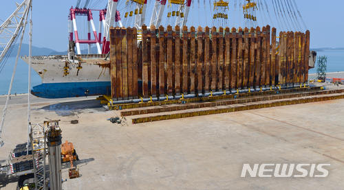 【목포=뉴시스】류형근 기자 = 10일 오후 12시10분께 전남 목포시 목포신항에서 현대삼호중공업 관계자들이 옆으로 누워 있는 세월호 바로 세우기(직립) 작업에 성공한 가운데 미수습·유가족 등이 지켜보고 있다. 2018.05.10.&nbsp; hgryu77@newsis.com