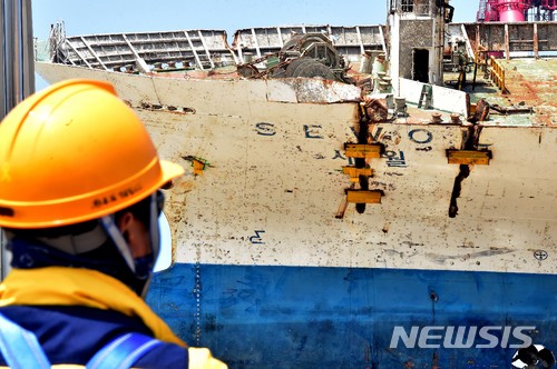 【목포=뉴시스】류형근 기자 = 세월호 직립 당일인 10일 전라남도 목포신항에서 세월호가 해상크레인에 의해 들어올려진 가운데 관계자가 선미 부분을 바라보고 있다. 2018.05.10. photo@newsis.com