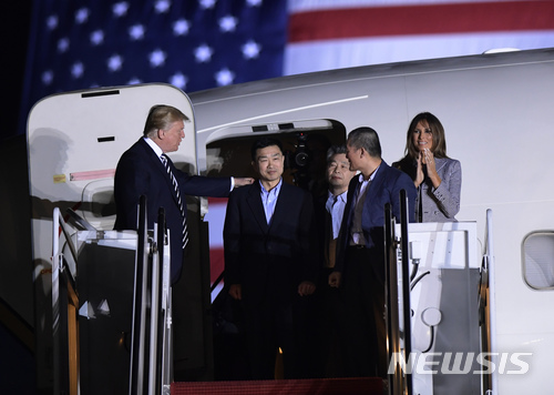 【앤드루스 공군기지=AP/뉴시스】북한에 억류됐다가 석방된 한국계 미국인 3명이 10일 오전(현지시간) 미국 메릴랜드주 앤드루스 공군기지에 도착해 비행기에서 모습을 드러내고 있다. 왼쪽부터 도널드 트럼프 대통령, 토니 김, 김학송, 김동철, 멜라니아 트럼프. 2018.05. 