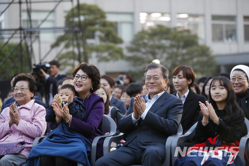 【서울=뉴시스】 문재인 대통령과 김정숙 여사는 10일 오후 취임 1주년을 맞아 청와대 인근 주민들을 초대해 '달빛이 흐른다'라는 작은 음악회를 가졌다. 김정숙 여사 품에 손자가 안겨 있다. 2018.05.10. (사진=청와대 제공) photo@newsis.com