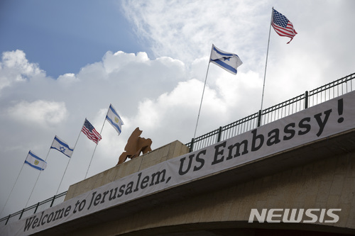 【예루살렘=AP/뉴시스】이스라엘 주재 미 대사관의 예루살렘 이전을 하루 앞둔 13일 예루살렘의 미 대사관 예정 건물이 있는 외교단지로 이르는 교량에 이스라엘 국기와 미 성조기가 내걸린 가운데 '미 대사관의 이전을 환영한다'는 글귀가 내걸려 있다. 팔레스타인은 미국의 대사관 이전에 대해 미국의 편견을 보여주는 것이라며 반발하고 있다. 2018.5.14