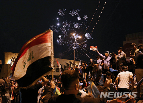 【바그다드(이라크) = AP/뉴시스】지난 12일 치러진 이라크 총선에서 시아파 종교지도자 무크타다 알사드르가 초기 개표에서 예상보다 좋은 성적을 거두자 14일(현지시간) 바그다드에서 지지자들이 환호하고 있다. 14일 현재 이라크 전체 주 가운데 절반 이상이 개표된 상황에서 알사드르는 득표율선두를 달리고 있다. 2018.05.14&nbsp; 