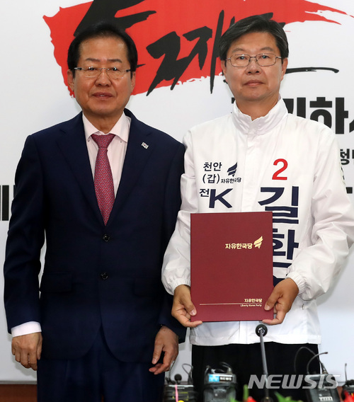 【천안=뉴시스】 자유한국당 홍준표 대표가 14일 오전 서울 여의도 당사 제1회의실에서 국회의원 재보궐선거 천안갑 길환영 후보에게 공천장을 수여하고 기념촬영을 하고 있다.  뉴시스DB.