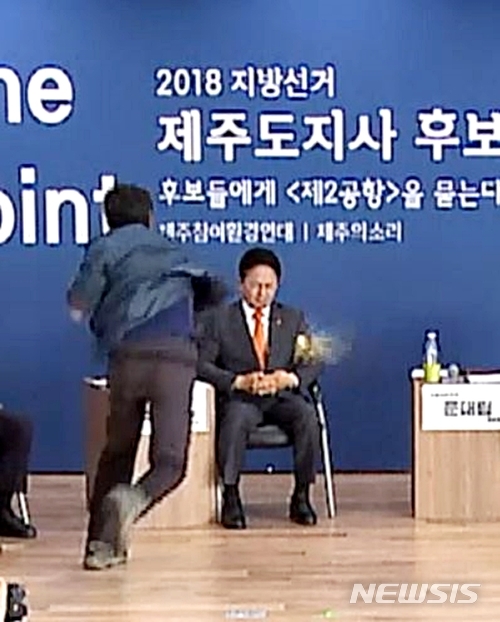 【제주=뉴시스】우장호 기자 = 무소속 원희룡(54) 후보가 지난 14일 오후 제주시 중앙로 제주벤처마루 10층에서 열린 제2공항 관련 후보 초청 토론회장에서 단상 위로 뛰어든 김경배(50) 제주 제2공항 성산읍반대대책위원회 부위원장에게 계란을 맞고 있다. 2018.05.15. (사진=제주의 소리 영상 캡처) woo1223@newsis.com