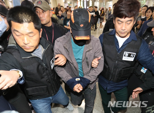 【제주=뉴시스】우장호 기자 = 16일 오후 제주국제공항 1층에서 장기 미제사건인 제주 보육교사 살인 사건 유력 용의자 박모(49)씨가 경찰에 압송돼 대합실을 빠져 나오고 있다. 박씨는 이날 오전 8시20분께 경북 영주시에서 경찰에 붙잡혔다. 2018.05.16. woo1223@newsis.com