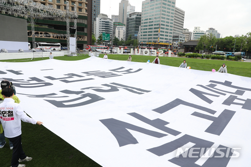 【서울=뉴시스】전진환 기자 = 청년임대주택 찬성 집회가 열린 17일 오전 서울시청 앞 광장에서 민달팽이유니온 및 임대주택 거주자, 예비입주자들이 대형플래카드를 들어보이고 있다. 2018.05.17. amin2@newsis.com
