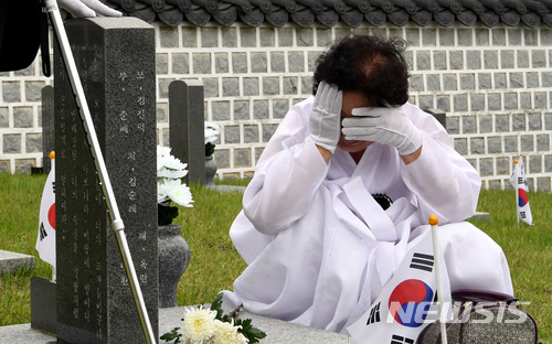 【광주=뉴시스】신대희 기자 = 5·18광주민주화운동 38주년 기념식을 하루 앞둔 17일 오전 광주 북구 운정동 국립5·18민주묘지에서 열린 추모제에 참석한 임옥한 열사(행방불명자)의 어머니 김진덕(74·여)씨가 열사의 묘역에서 오열하고 있다. 2017.05.17. sdhdream@newsis.com