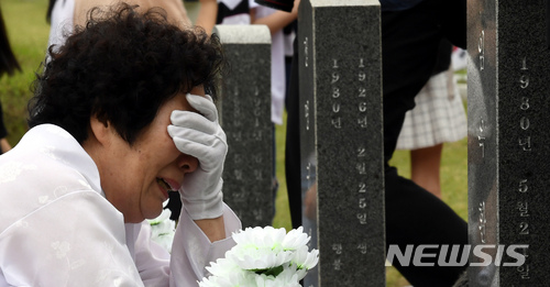 【광주=뉴시스】신대희 기자 = 5·18광주민주화운동 38주년 기념식을 하루 앞둔 17일 오전 광주 북구 운정동 국립5·18민주묘지에서 열린 추모제에 참석한 임옥환 열사(행방불명자)의 어머니 김진덕(74·여)씨가 행불자 묘역에서 오열하고 있다. 2017.05.17. sdhdream@newsis.com