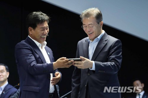 【서울=뉴시스】전신 기자 = 문재인 대통령이 17일 서울 마곡 R&D 단지에서 열린 ‘2018 대한민국 혁신성장 보고대회’에서 스마트폰을 이용한 스마트팜 원격 제어 시연을 살펴보고 있다. 2018.05.17. photo1006@newsis.com