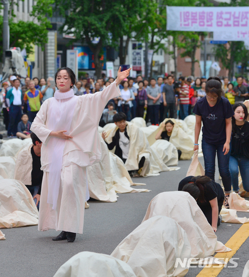 【광주=뉴시스】류형근 기자 = 1980년 5월 광주를 재현해 진상규명 공감대를 모으는 38주기 5·18민주화운동 전야행사가 '보아라 오월의 진실, 불어라 평화의 바람'을 주제로 17일 오후 광주 동구 금남로 거리에서 펼쳐졌다. 고(故) 김영철 열사의 막내 딸 연우씨가 아버지를 비롯한 그날의 희생자 영혼을 깨우는 몸짓을 선보이고 있다. 2018.05.17. hgryu77@newsis.com