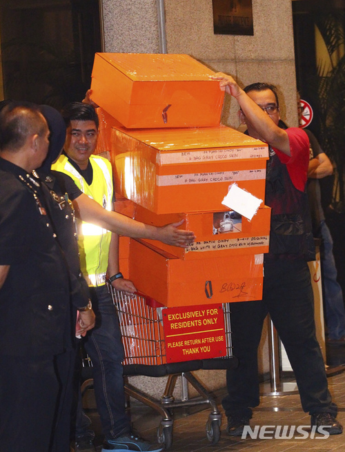 【쿠알라룸푸르(말레이시아)=AP/뉴시스】말레이시아 경찰이 18일 쿠알라룸푸르의 나집 라작 전 총리 저택을 압수수색하면서 압수한 명품 백이 든 상자들을 트럭으로 옮겨 싣고 있다. 나집 전 총리의 부패 스캔들에 대해 조사하고 있는 경찰은 이날 수백점의 명품 백들과 현금, 보석 등 귀중품들을 압수했다. 2018.05.18